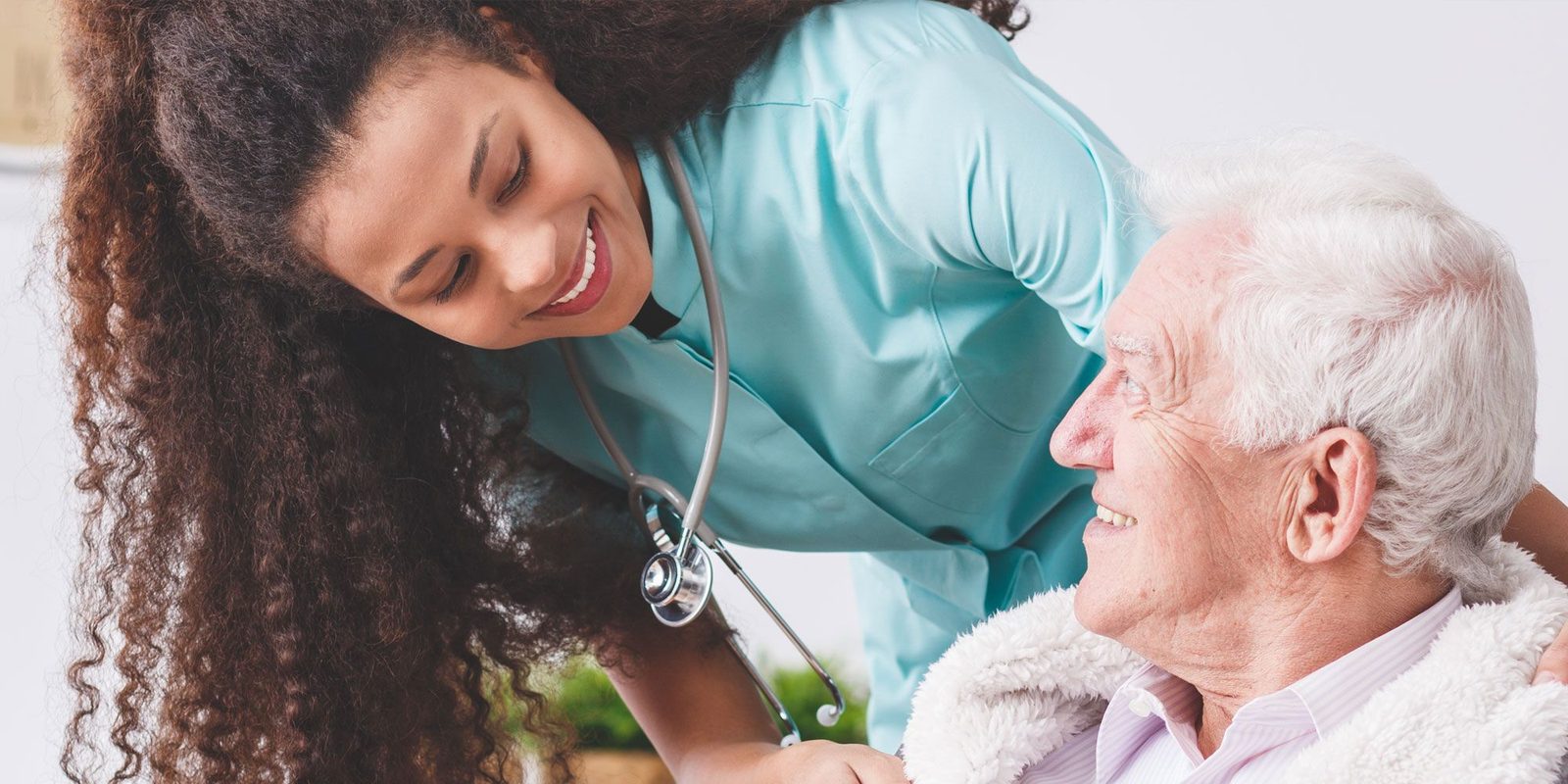An older woman smiling at home beside her live-in carer